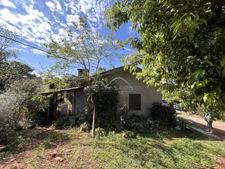 Fachada de uma residência em Lajeado, Brasil, parcialmente coberta por vegetação.