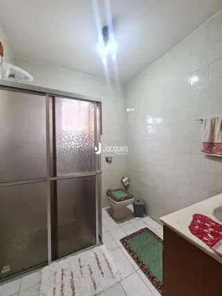 Interior com paredes de azulejo branco e área de banho.