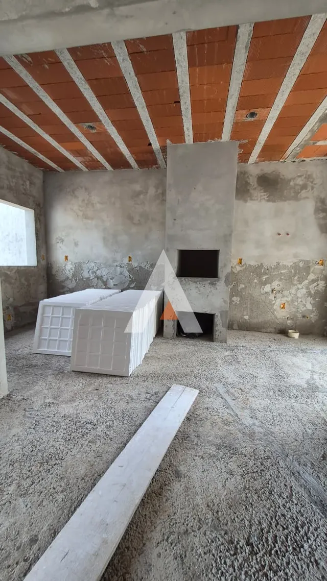 Interior de uma construção em fase de acabamento com teto de madeira exposto.