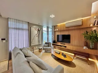 Sala de estar com sofá e painel de madeira em um imóvel no Brasil.