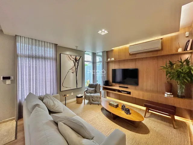 Sala de estar com sofá e painel de madeira em um imóvel no Brasil.