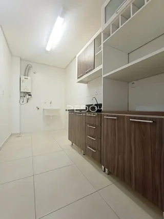 Hall de entrada com piso claro e armários em madeira.
