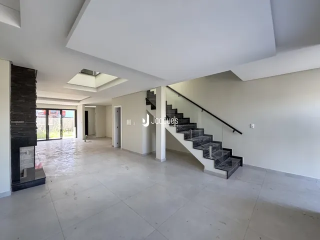 Ambiente interno de uma sala de estar com piso de concreto polido e escadaria de mármore.