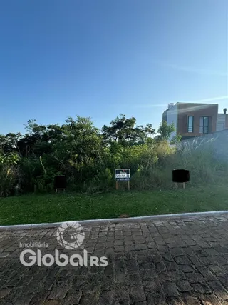 Vista externa de uma propriedade com vegetação ao fundo.