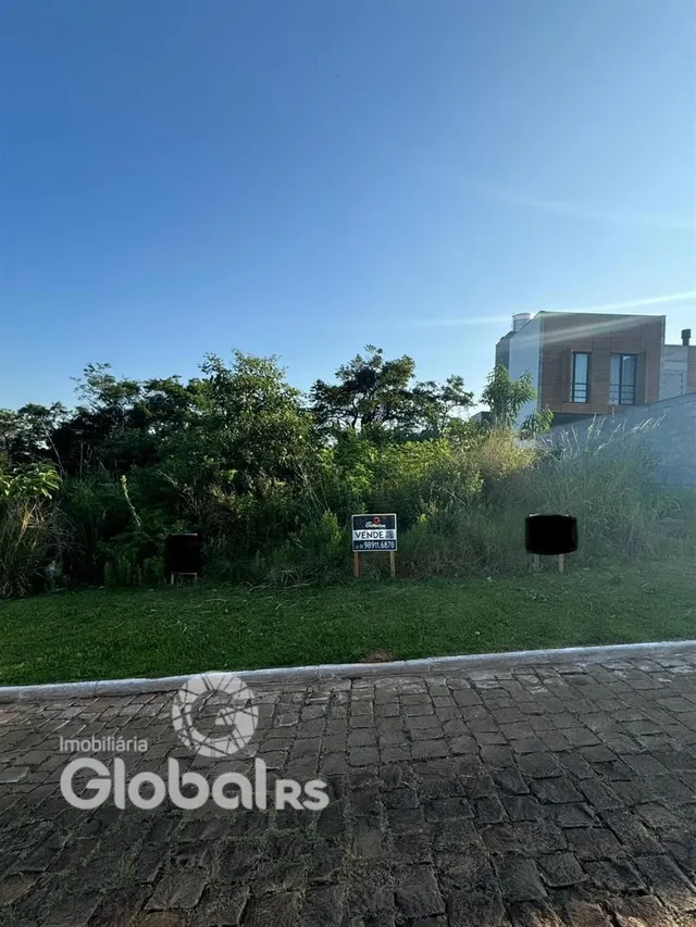 Vista externa de uma propriedade com vegetação ao fundo.