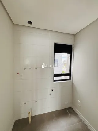 Foto de um canto de cômodo interno com paredes brancas e uma janela.