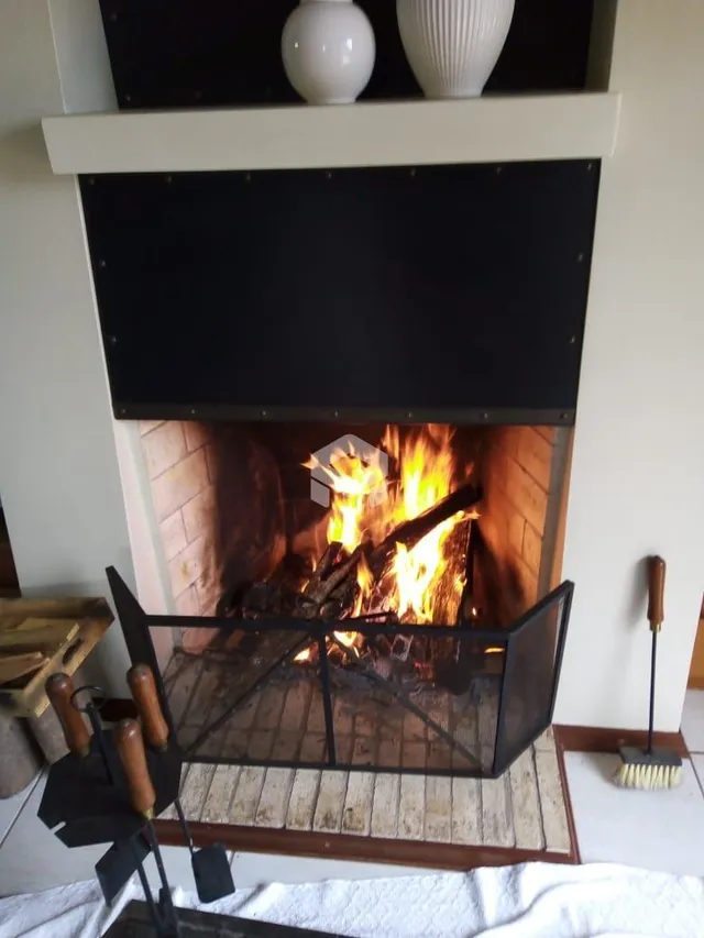 Lareira com fogo visível na parede da residência.