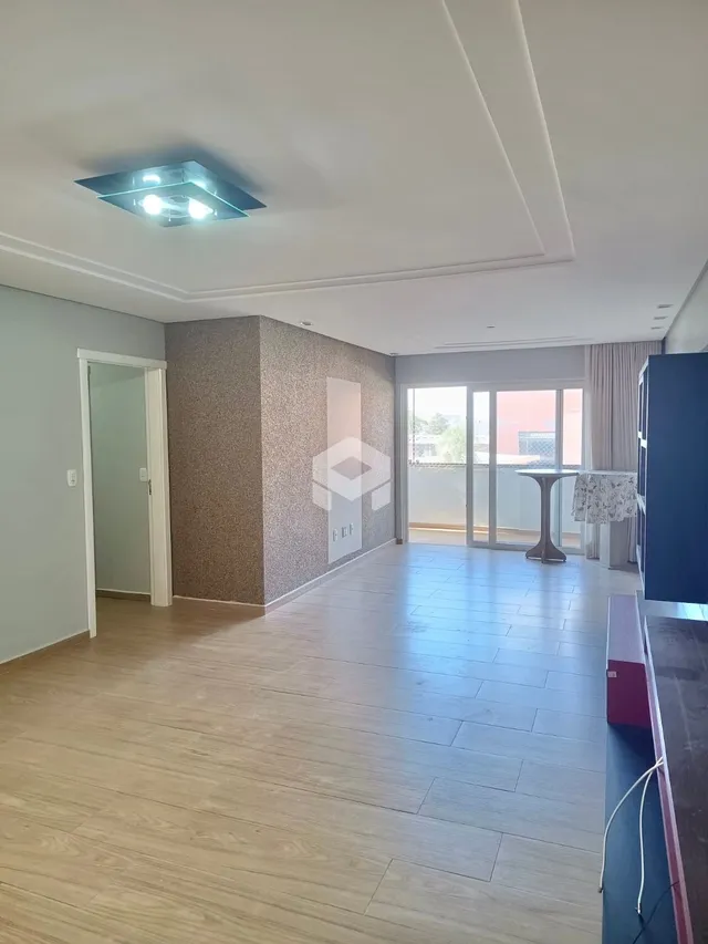 Vista interna de um ambiente com piso de madeira clara e paredes neutras.