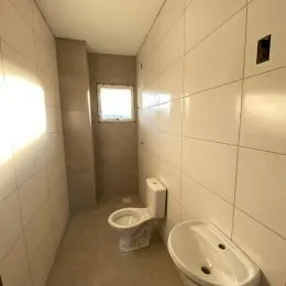Foto de um banheiro com paredes brancas e um vaso sanitário.