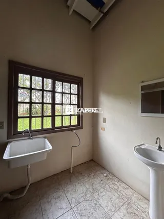 Foto de um banheiro com janela e pia de louça branca.