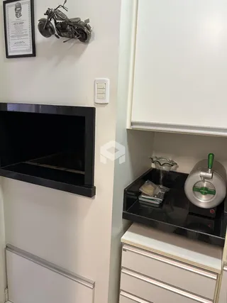 Vista de um corredor interno com nicho e armários de cozinha.
