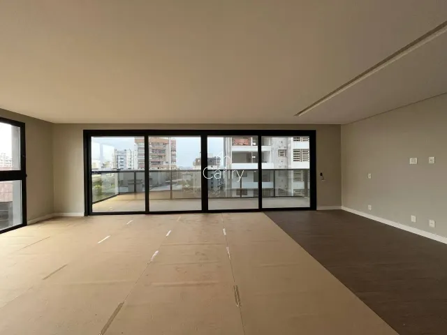 Ambiente interno com grandes portas de vidro que oferecem vista para o horizonte da cidade.