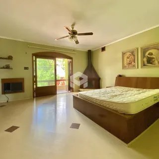 Quarto com cama e porta de vidro de madeira em uma residência.
