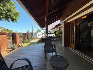 Deck de madeira com móveis externos em uma área externa.