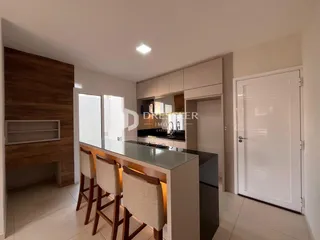 Ambiente interno de sala de estar com bancada de cozinha em Lajeado.