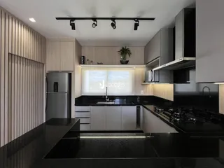 Cozinha moderna com armários de madeira e bancadas escuras.