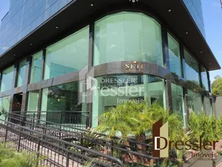 Fachada de um edifício moderno com grandes janelas de vidro.