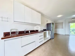 Foto de uma cozinha com armários brancos e bancada escura.