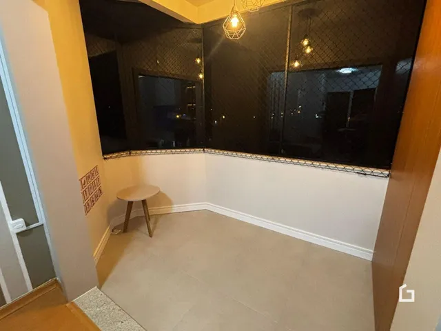 Vista de um corredor interno com piso de cerâmica e divisória de vidro decorativa.