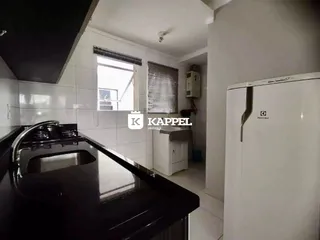 Esta é uma foto da cozinha com bancada escura e revestimento branco.