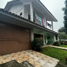 Fachada de uma residência com garagem e telhado inclinado.