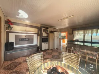 Ambiente interno de uma sala de estar com piso de cerâmica e móveis de madeira.