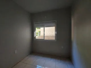 Vista interna de um ambiente com piso de cerâmica e janela.