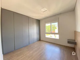Ambiente interno com armários embutidos e piso de madeira clara.