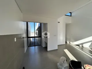 Hall de entrada com piso de cerâmica e paredes brancas em um imóvel.