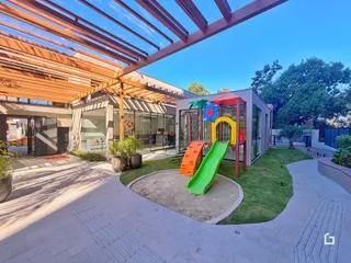 Vista externa de uma residência moderna com área de lazer e playground.