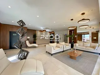 Sala de estar ampla com sofás brancos em um imóvel.