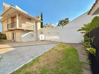 Fachada de uma casa em Lajeado, Brasil, com jardim e muro branco.