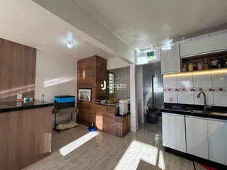 Interior de uma cozinha e sala de estar com armários modernos e piso de cerâmica.