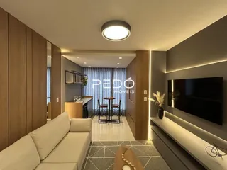 Sala de estar com revestimento de madeira e sofá claro.