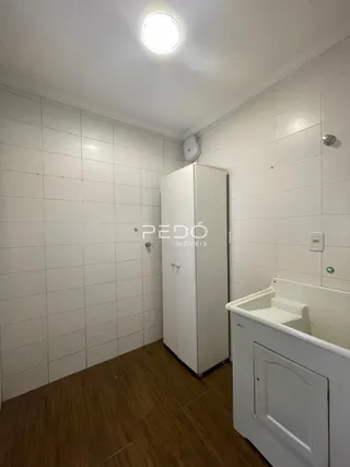 Foto interna de um banheiro com piso de madeira e paredes brancas.