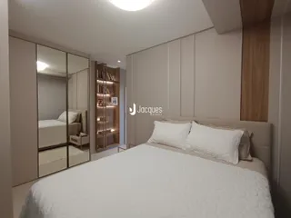 Quarto com armários embutidos e cabeceira de madeira.