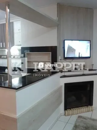 Sala de estar com televisão e lareira em ambiente interno.