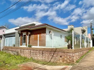 Fachada de uma casa em Lajeado, Brasil, com muro de tijolos e cerca de vidro.