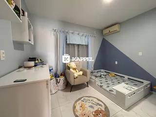 Quarto com cama e janela em um apartamento com decoração clara.