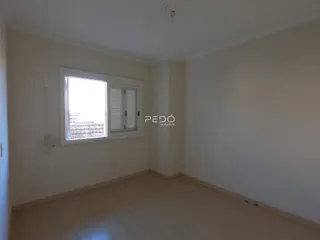 Ambiente interno de uma sala com piso claro e janela.
