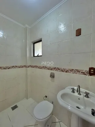 Interior de um banheiro com revestimento cerâmico branco.