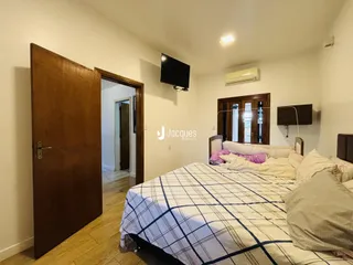 Quarto com cama e televisão em um imóvel no Brasil.