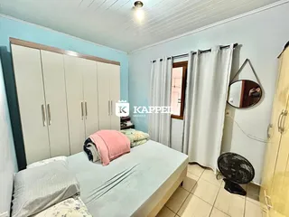 Quarto com cama e armário branco em um imóvel.