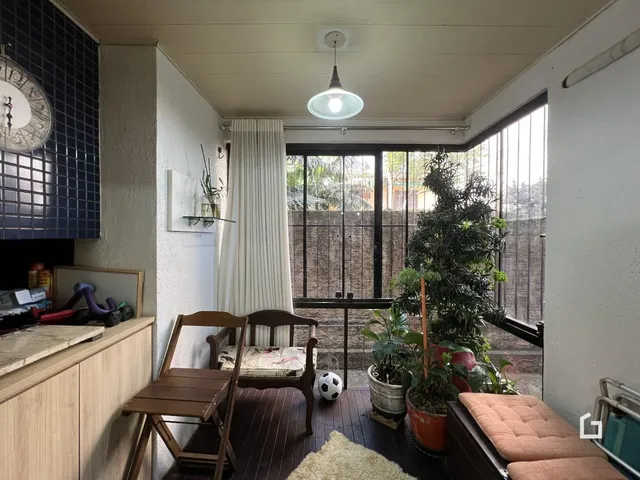 Ambiente interno com piso de madeira e vista para o exterior.