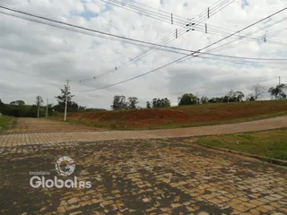 Vista da propriedade com estrada e terra no primeiro plano.