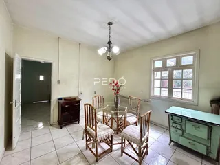 Uma sala de jantar com mesa e cadeiras de madeira em um imóvel no Brasil.