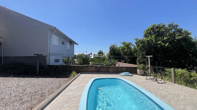 Fachada de uma casa com piscina no quintal.
