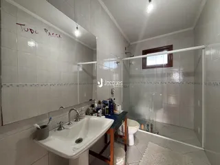 Foto de um banheiro com revestimento cerâmico branco.