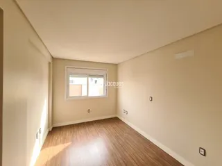 Interior de um cômodo com piso de madeira e paredes claras.