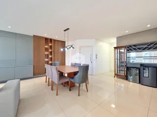 Sala de jantar com mesa de madeira e armários modernos.